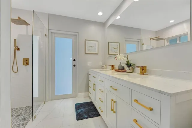 a bathroom with a sink a mirror and a shower