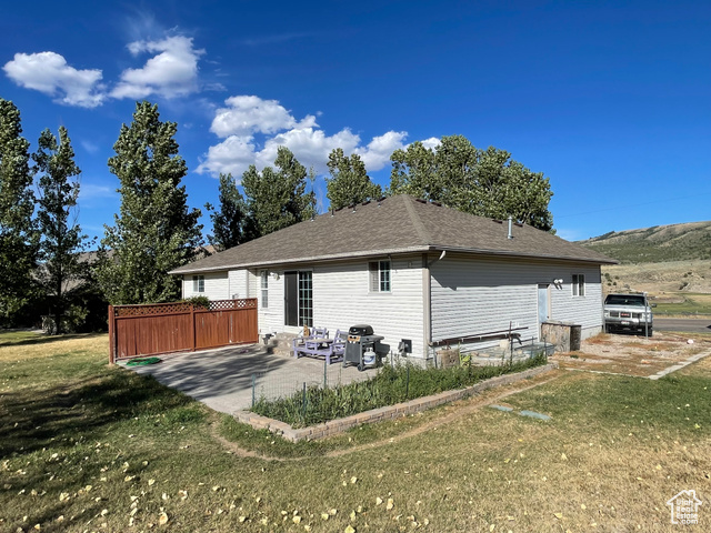 11473 South Dempsey Creek Road Lava Hot Springs, ID 83246 - Photo 33 of 47 Rear view of property featuring a patio, a shingled roof, and a lawn