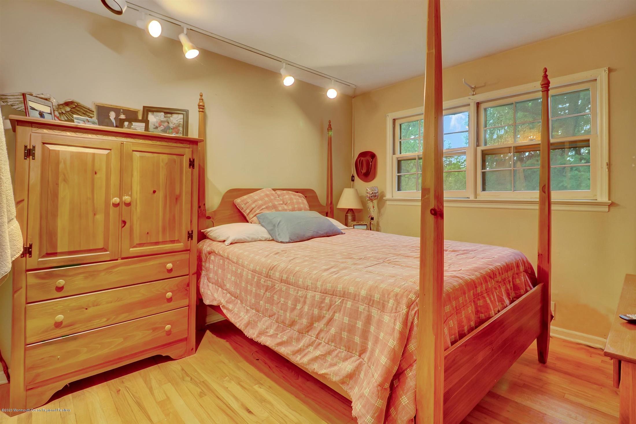 107 Jumping Brook Road Lincroft, NJ 07738 - Photo 18 of 30 a bedroom with a bed and wooden floor