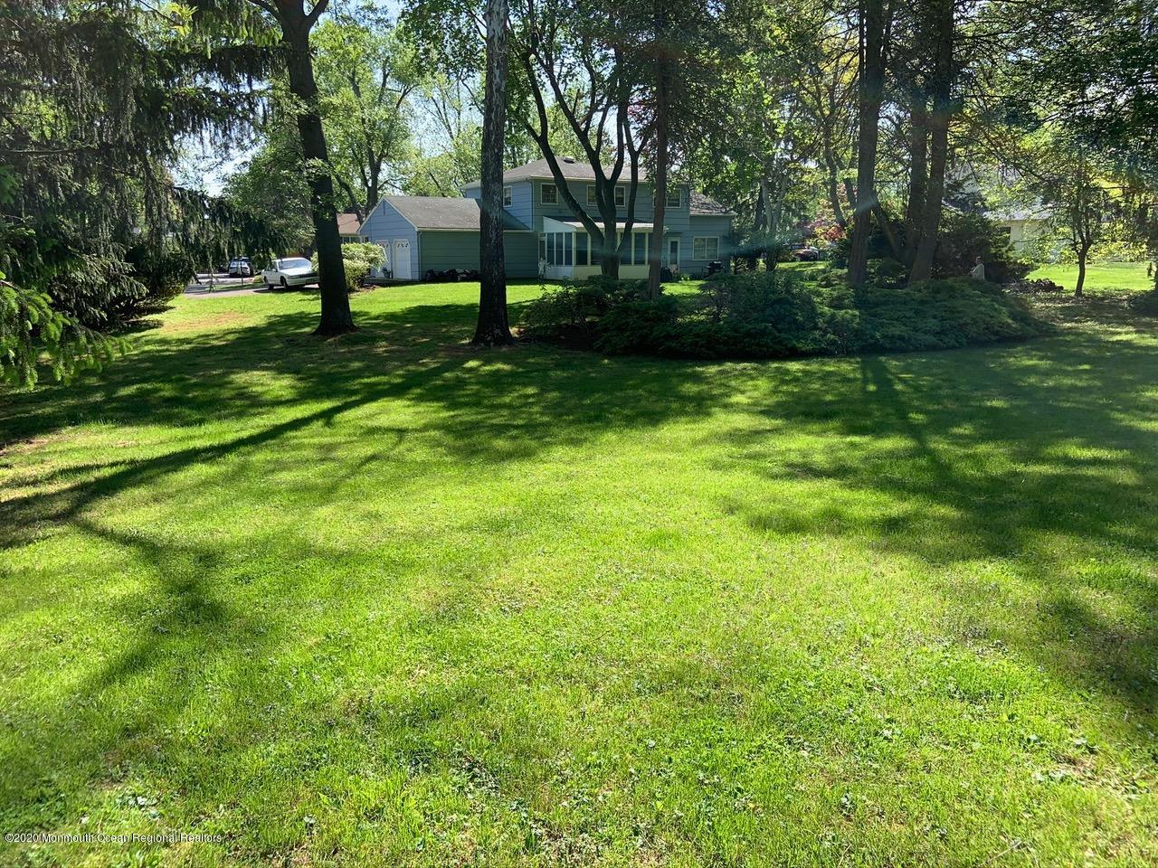 107 Jumping Brook Road Lincroft, NJ 07738 - Photo 4 of 30 a view of a backyard with large trees