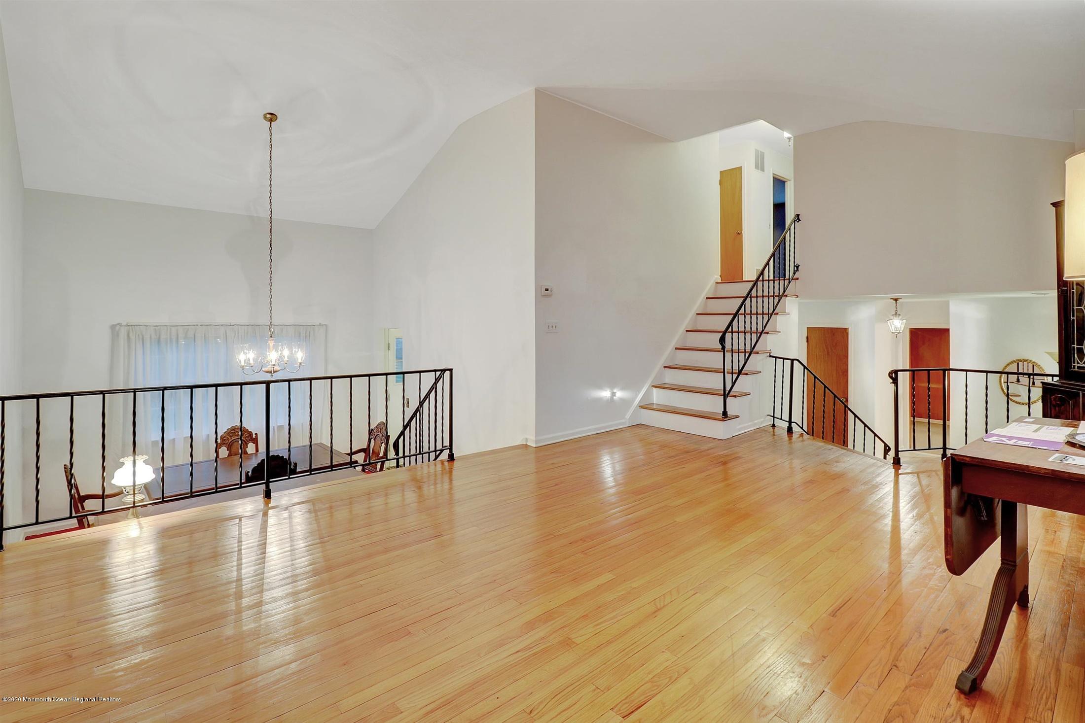 107 Jumping Brook Road Lincroft, NJ 07738 - Photo 9 of 30 a hallway with wooden floor table and chairs