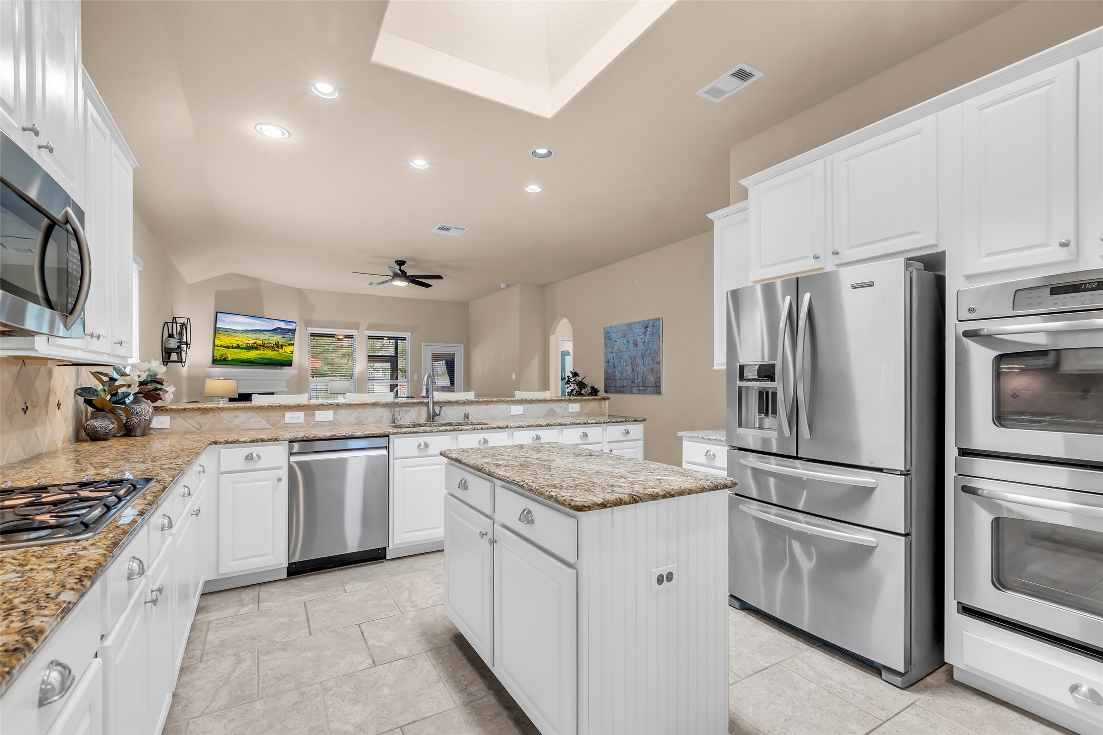 a kitchen with stainless steel appliances granite countertop a sink stove and refrigerator