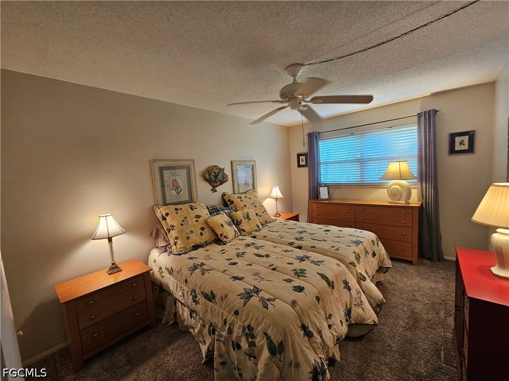 6777 Winkler Road, Unit 168 Fort Myers, FL 33919 - Photo 13 of 15 a bedroom with a bed a lamp and a chandelier