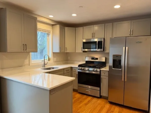 a kitchen with a sink a microwave a stove and refrigerator