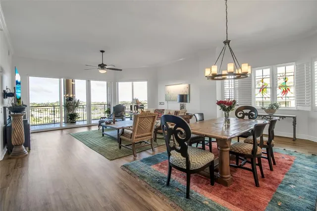 a view of a dining room and livingroom with furniture wooden floor a chandelier