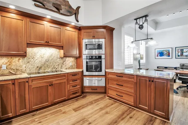 a kitchen with stainless steel appliances granite countertop a stove and cabinets
