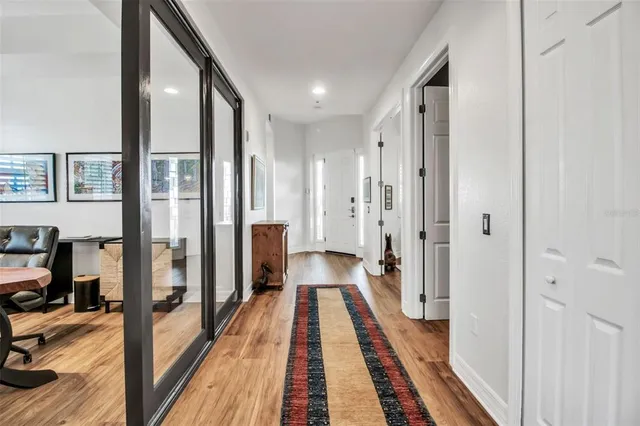 a view of a hallway with wooden floor and furniture