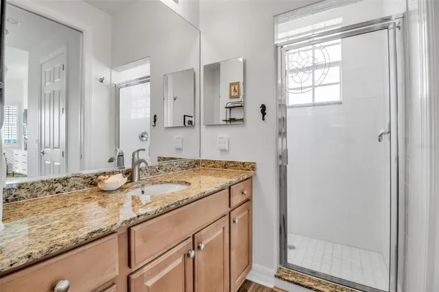 a bathroom with a granite countertop sink and a mirror