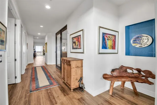 a view of a hallway with wooden floor and furniture