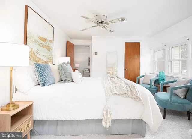 a bedroom with a bed a couch and a large window