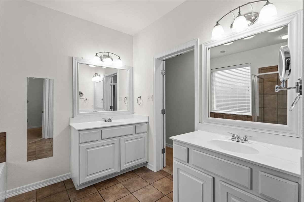 2304 Village View Loop Pflugerville, TX 78660 - Photo 28 of 40 Dual vanity sinks and a tiled shower create a functional, well-appointed primary bathroom.