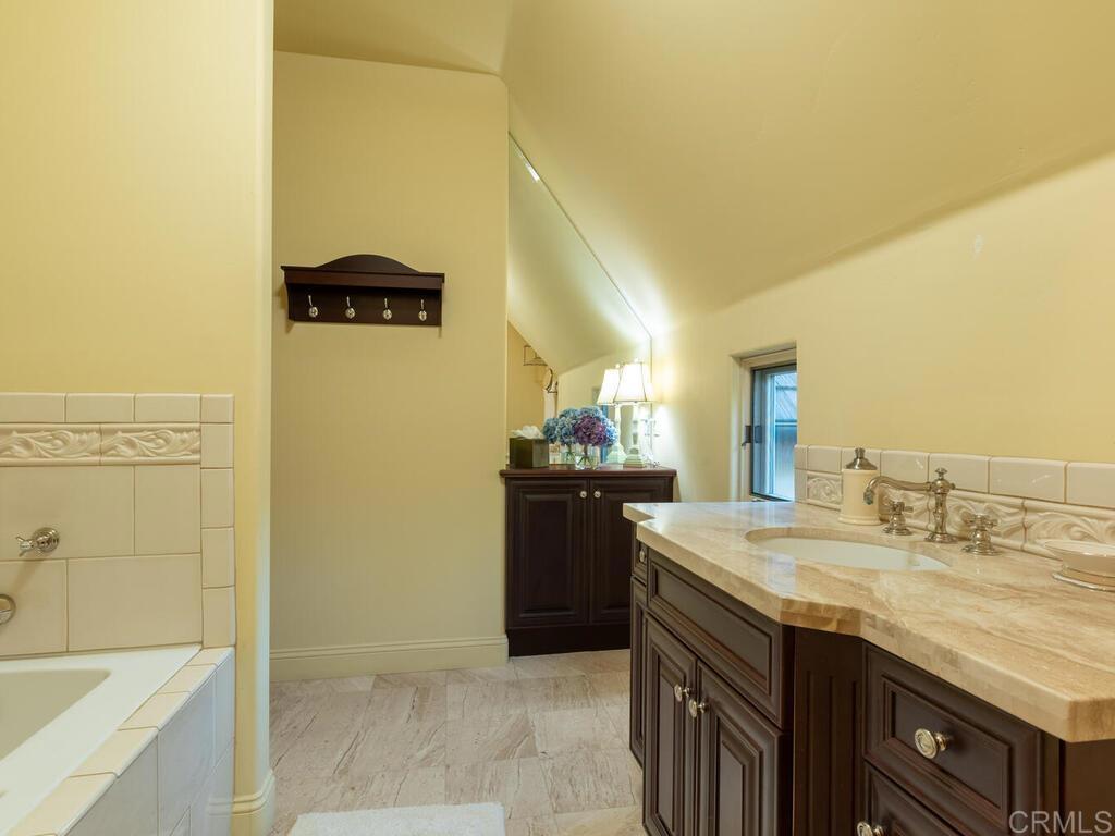 31267 Rancho Amigos Road Bonsall, CA 92003 - Photo 38 of 74 a bathroom with a granite countertop sink and a mirror