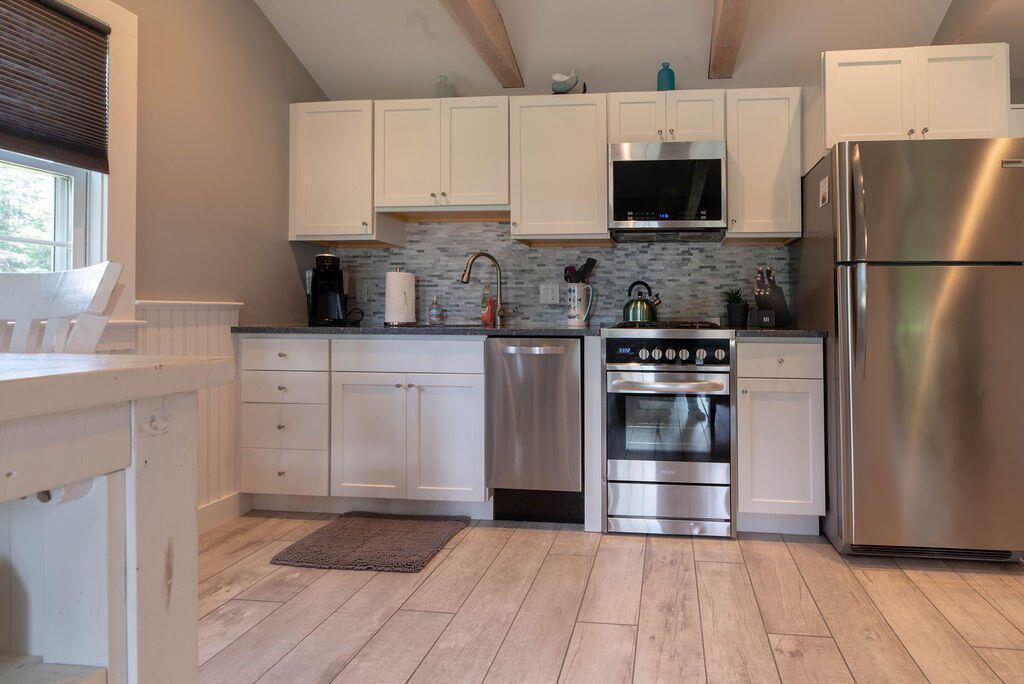 170 Beach Road, Unit 2A Orleans, MA 02653 - Photo 4 of 11 a kitchen with white cabinets and stainless steel appliances
