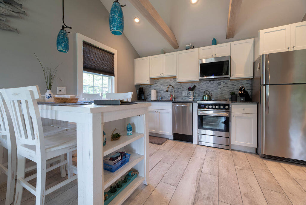 170 Beach Road, Unit 2A Orleans, MA 02653 - Photo 5 of 11 a kitchen with stainless steel appliances granite countertop a stove top oven a sink and a refrigerator