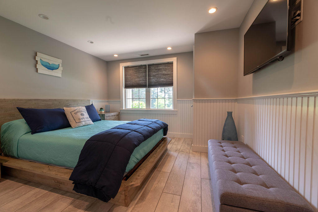 170 Beach Road, Unit 2A Orleans, MA 02653 - Photo 6 of 11 a bedroom with a large bed and a flat tv screen on a dresser