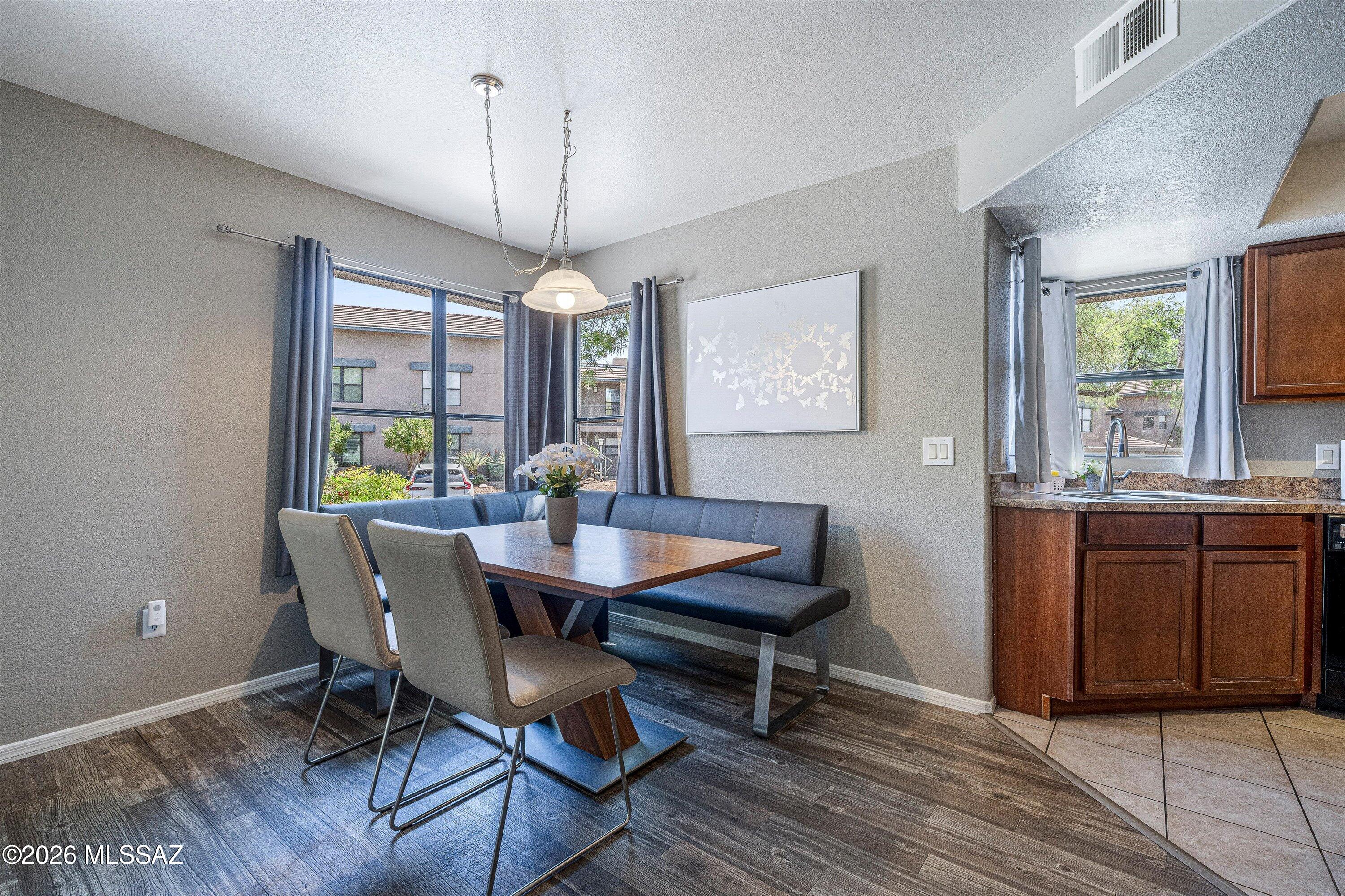 5855 North Kolb Road, Unit 8106 Tucson, AZ 85750 - Photo 10 of 34 a dining room with wooden floor a chandelier a wooden table and chairs