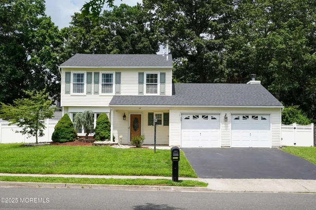 a front view of a house with a yard and trees