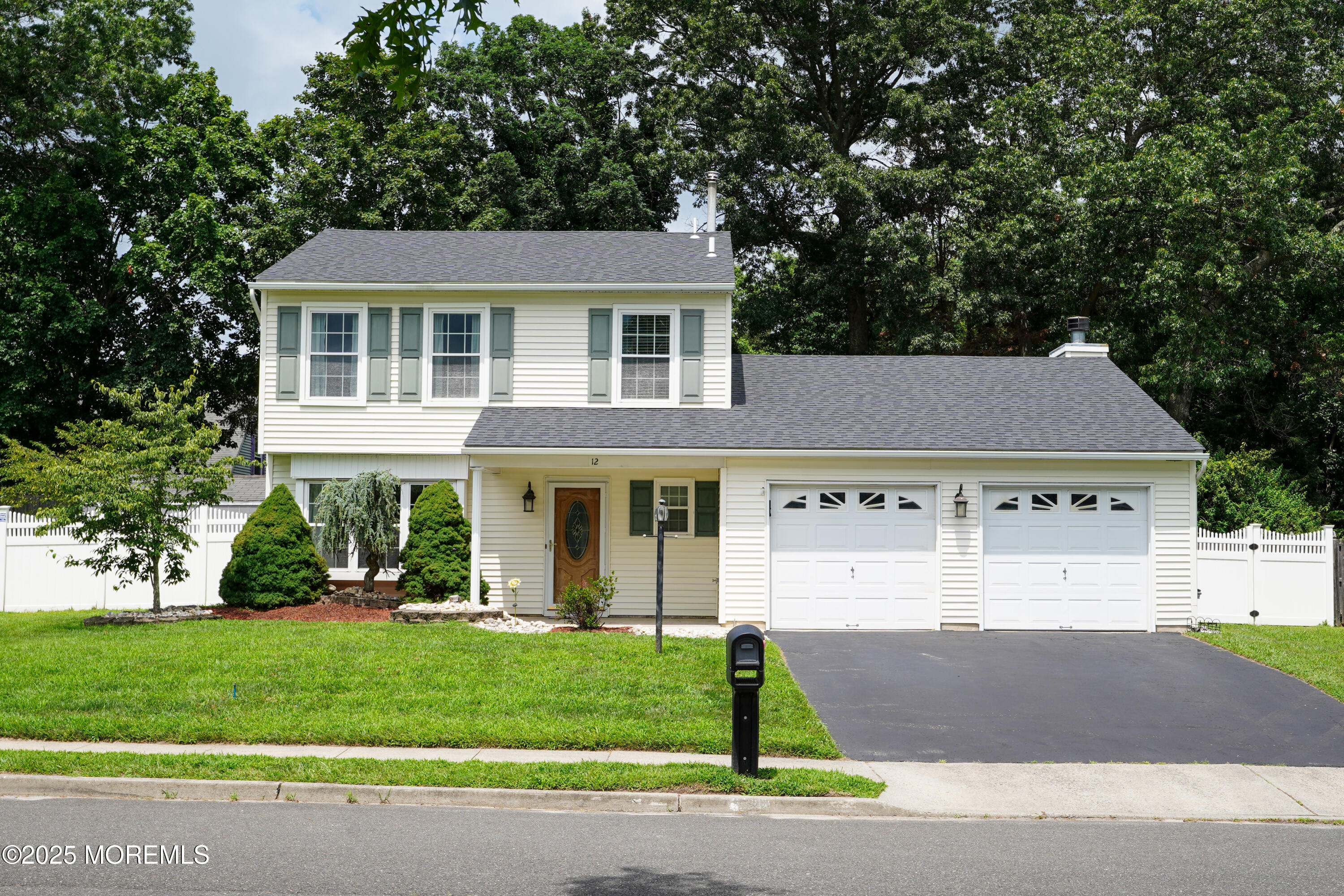 a front view of a house with a yard and trees