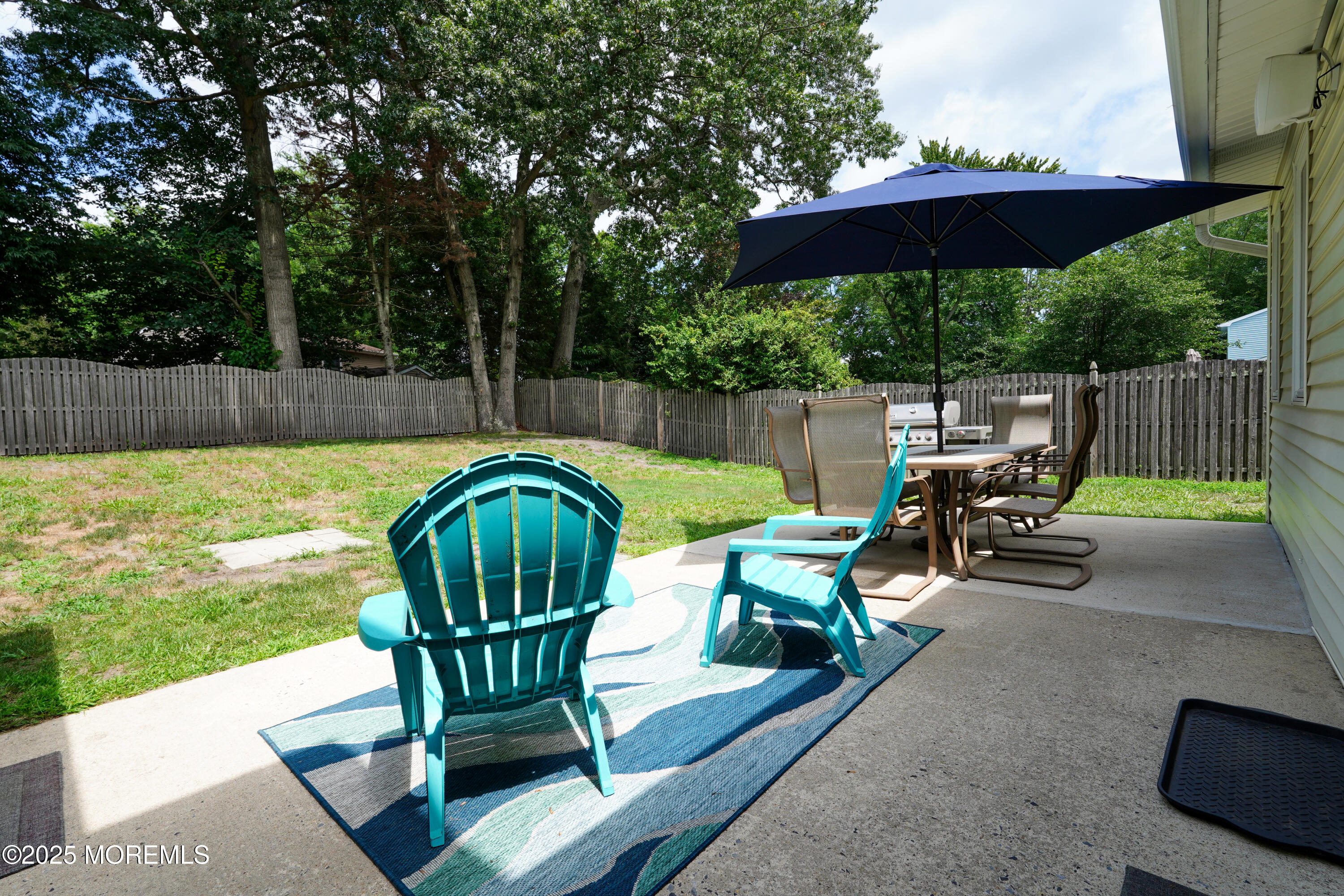 12 Quailtree Lane Howell, NJ 07731 - Photo 49 of 51 a view of a patio with table and chairs under an umbrella with a small yard