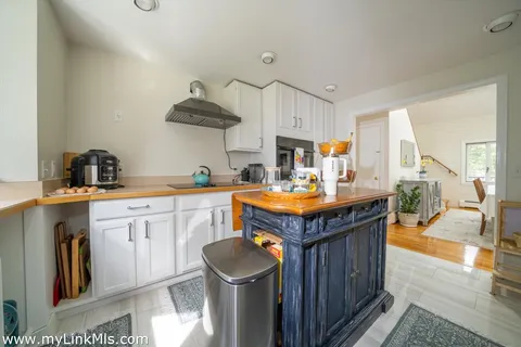 a kitchen with granite countertop a sink a counter space and cabinets