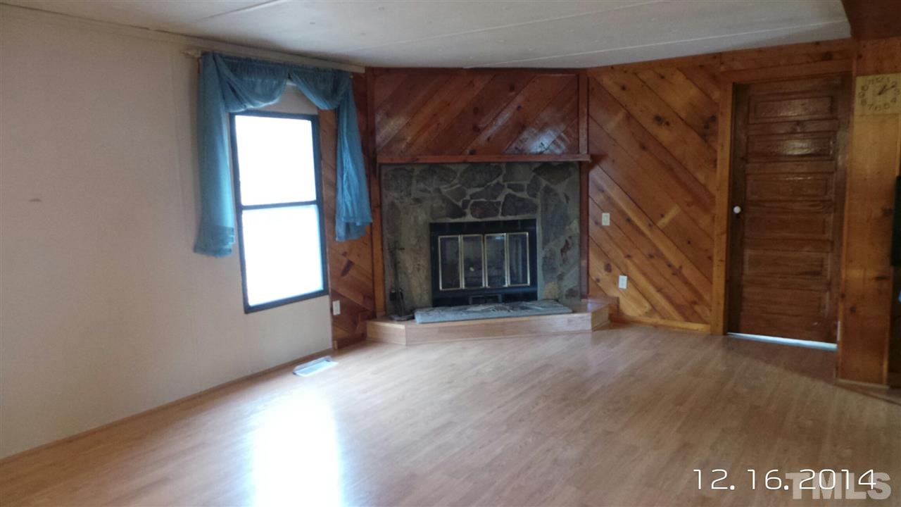 696 Lamms Grove Road Carthage, NC 28327 - Photo 3 of 9 a view of an empty room with wooden floor and a window