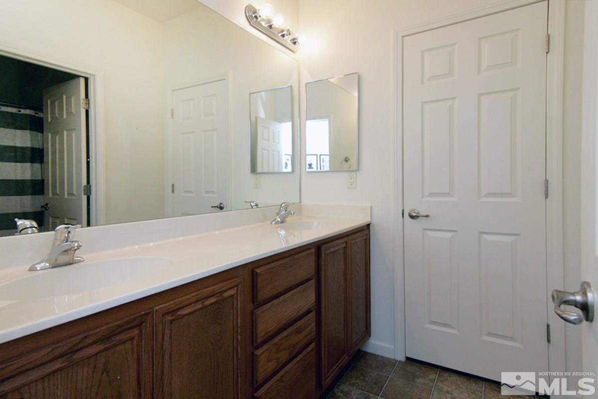 11032 Colton Drive Reno, NV 89521 - Photo 21 of 24 a bathroom with a double vanity sink and a mirror