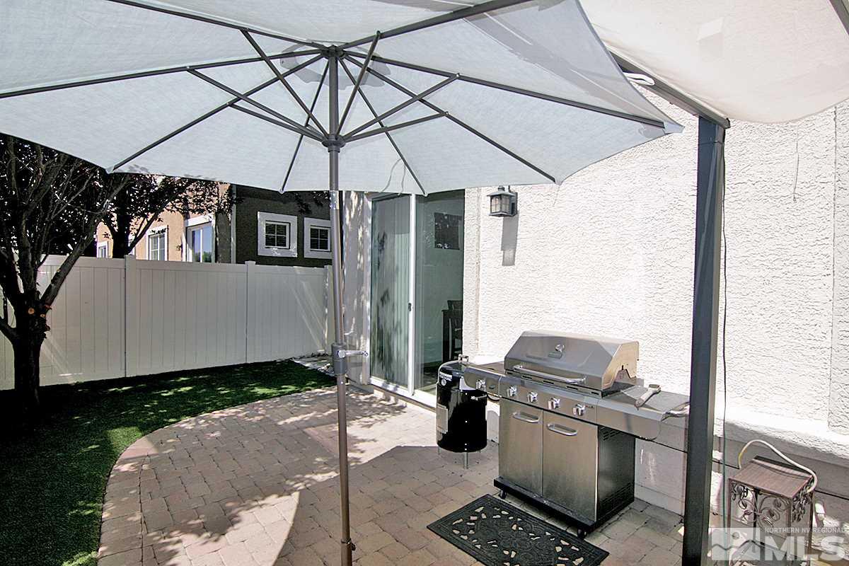 11032 Colton Drive Reno, NV 89521 - Photo 22 of 24 a patio with a table and chairs under an umbrella