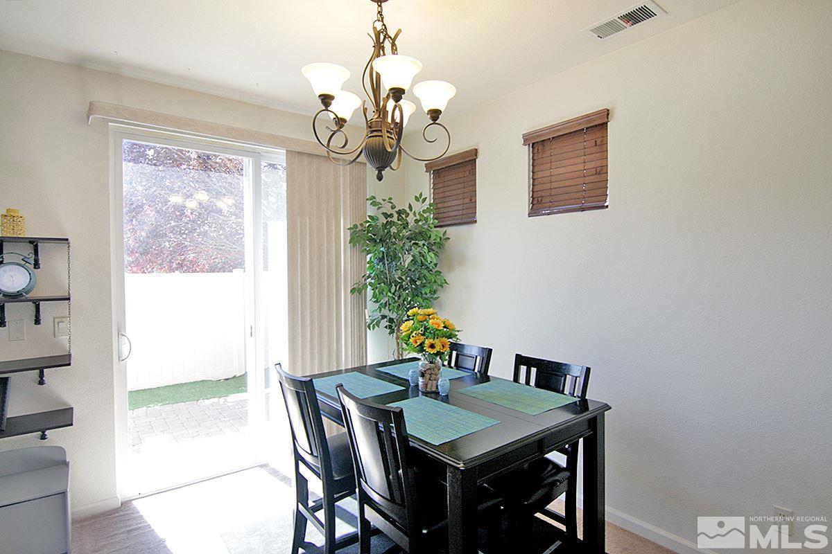 11032 Colton Drive Reno, NV 89521 - Photo 5 of 24 a view of a dining room with furniture a chandelier and wooden floor