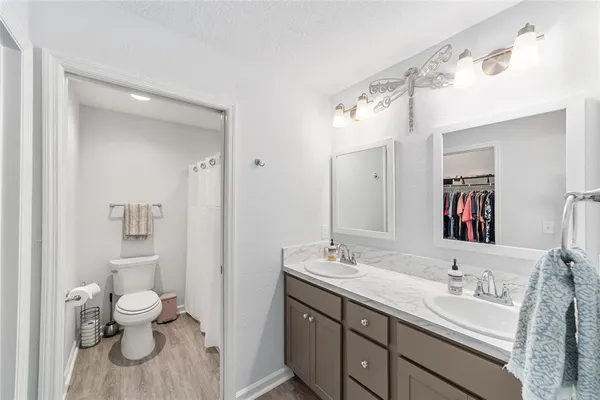 a bathroom with a granite countertop sink a toilet and a mirror