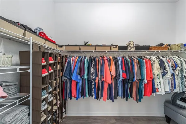 a view of walk in closet with clothes