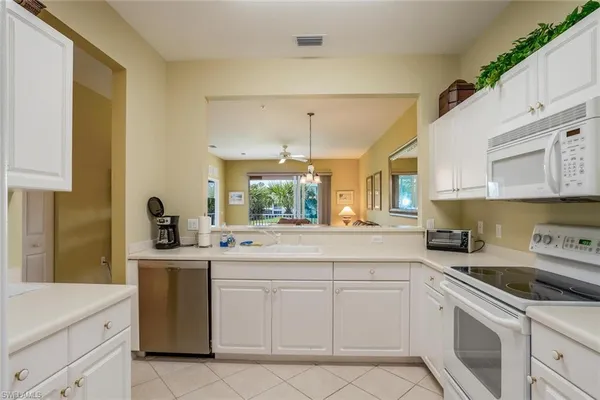 a kitchen with white cabinets appliances and a sink