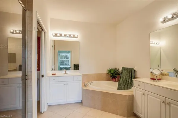 a bathroom with a tub sink and mirror