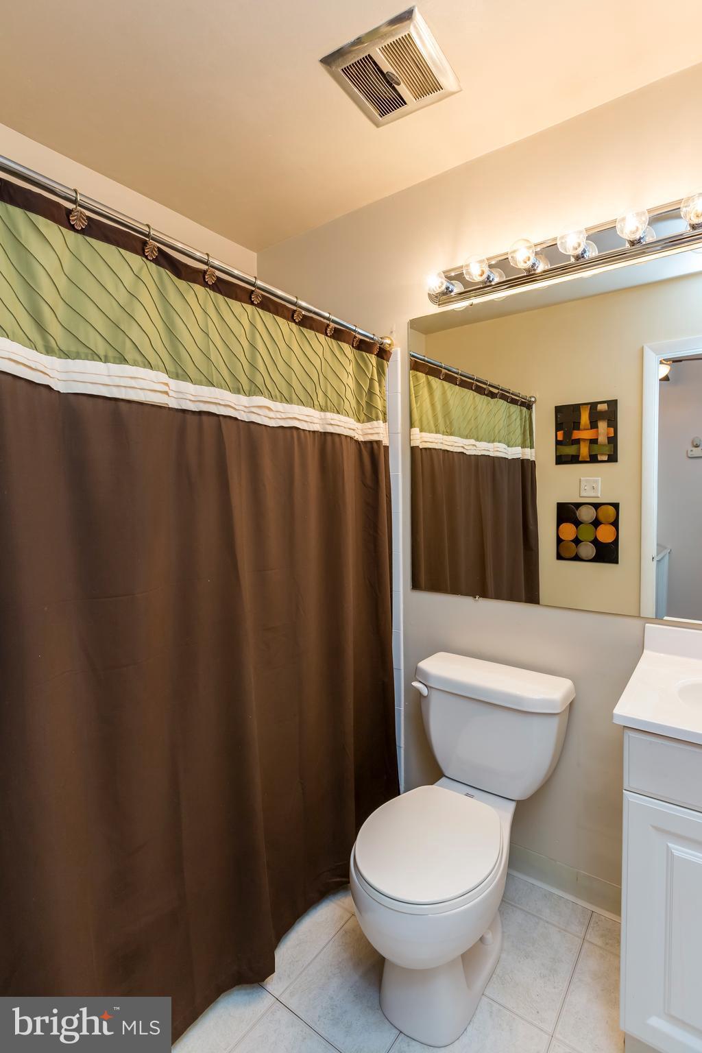 3937 Setonhurst Road Baltimore, MD 21208 - Photo 27 of 29 a white toilet sitting next to a bathroom sink and a shower