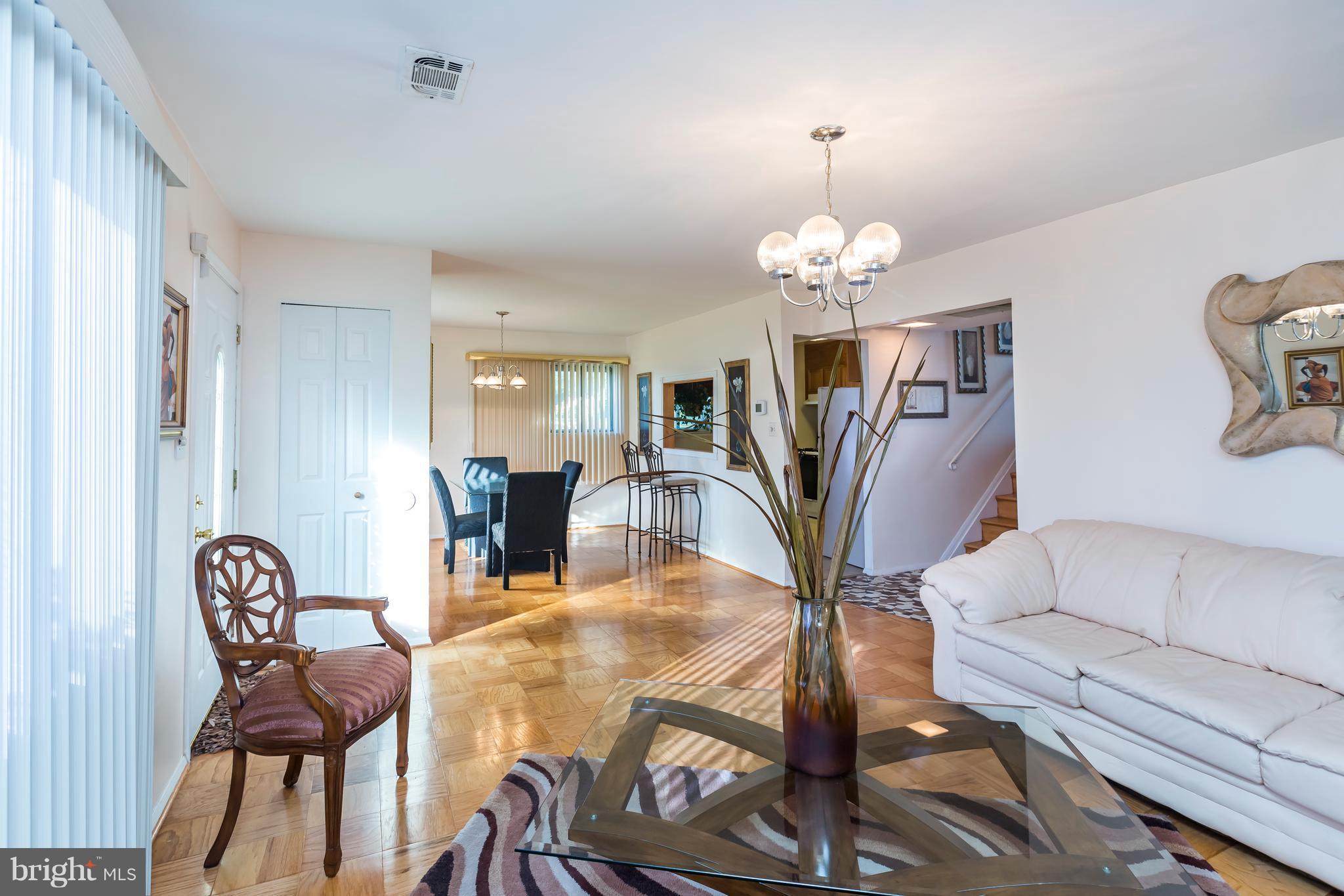 3937 Setonhurst Road Baltimore, MD 21208 - Photo 7 of 29 a living room with furniture a dining table and a chandelier