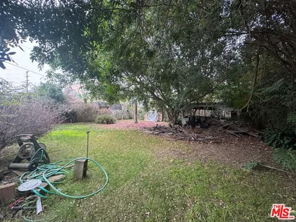 a backyard of a house with fountain table and chairs