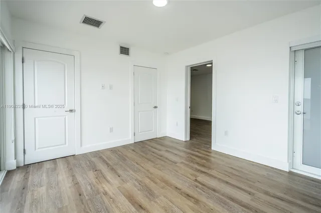 a view of an empty room with wooden floor