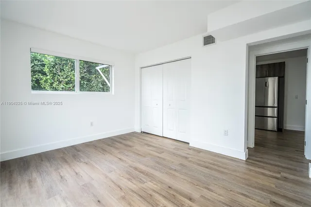 an empty room with wooden floor and a window