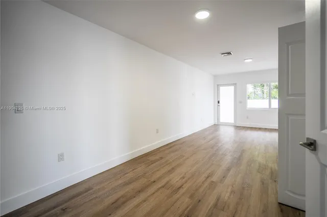 a view of an empty room and wooden floor