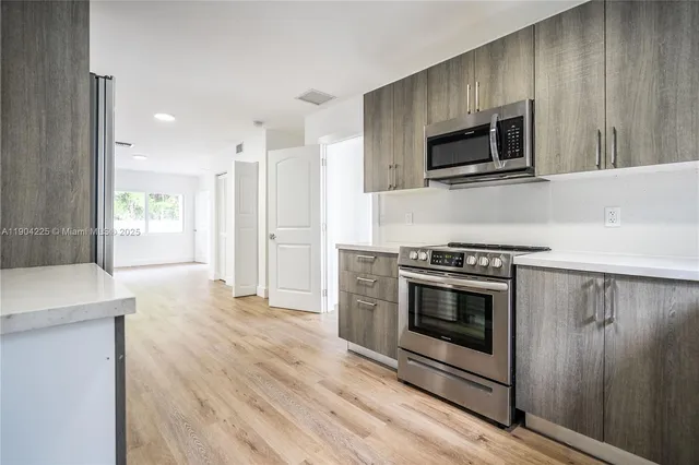 a kitchen with stainless steel appliances a stove a microwave and sink