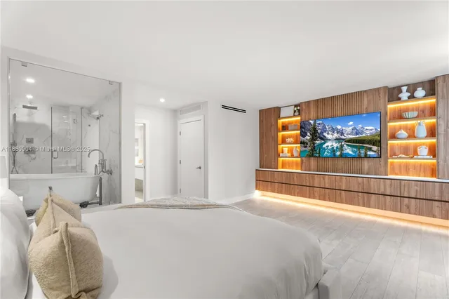 a bedroom with a bed and a flat screen tv