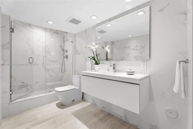 a bathroom with a bathtub shower sink mirror and toilet