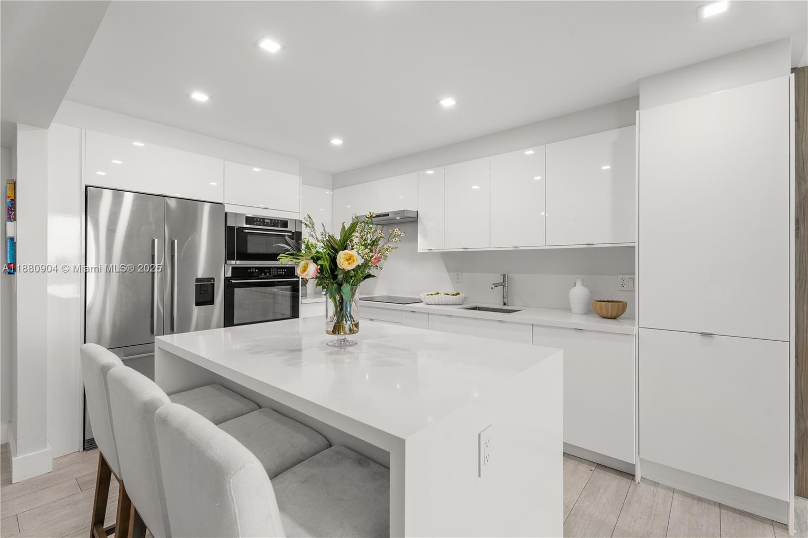 2301 Collins Avenue, Unit 152324 Miami Beach, FL 33139 - Photo 3 of 26 a kitchen with stainless steel appliances a sink a refrigerator and a counter top space
