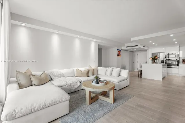 a living room with furniture and view of kitchen