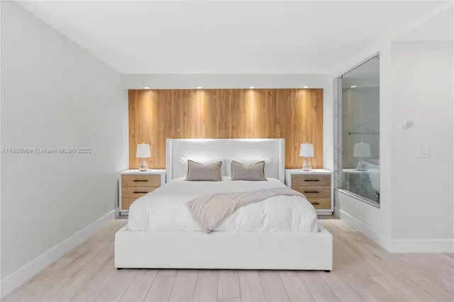 a bedroom with a white bed and a large window