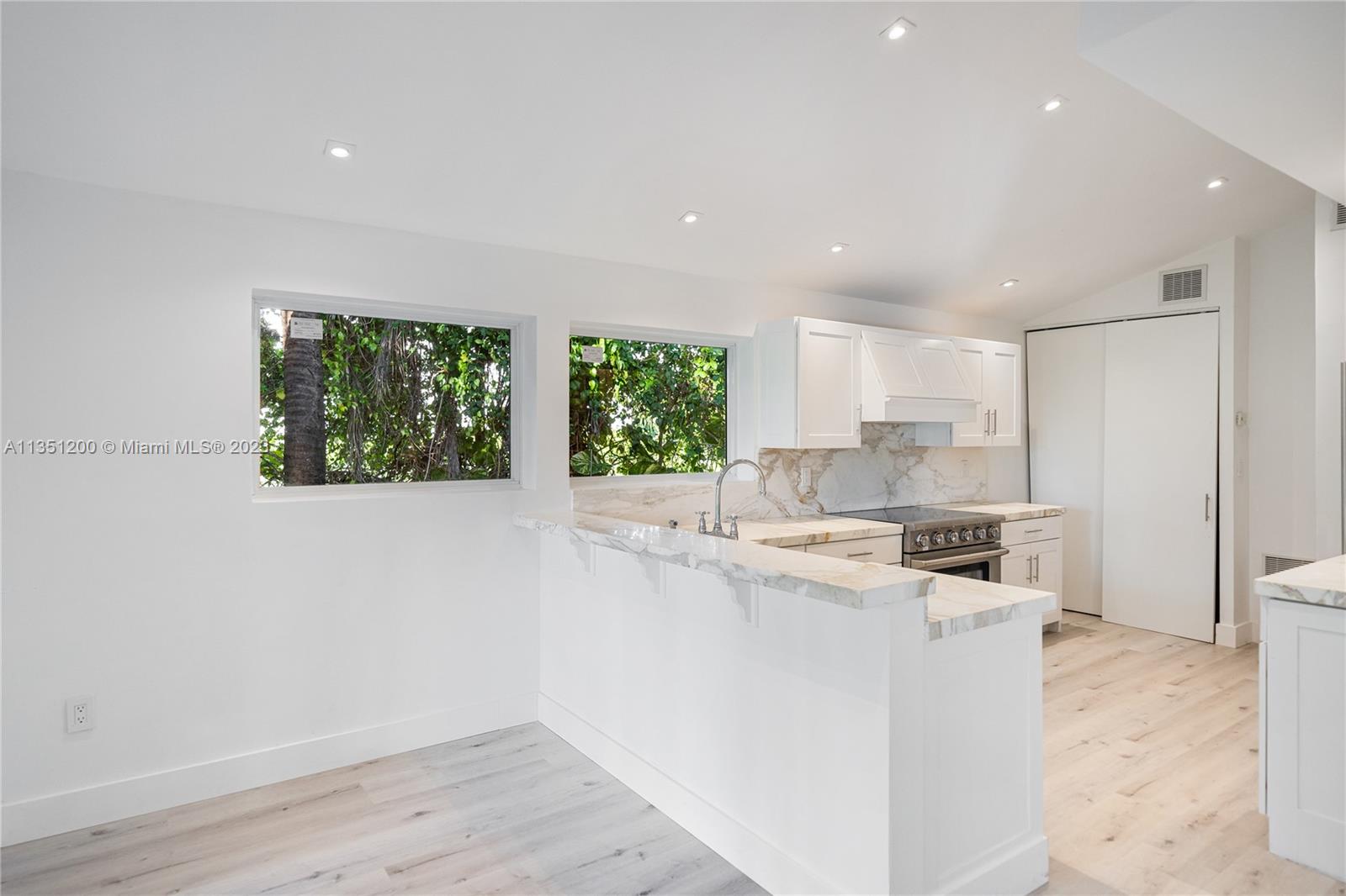 5512 La Gorce Drive Miami Beach, FL 33140 - Photo 14 of 35 a kitchen with a stove a sink and a refrigerator