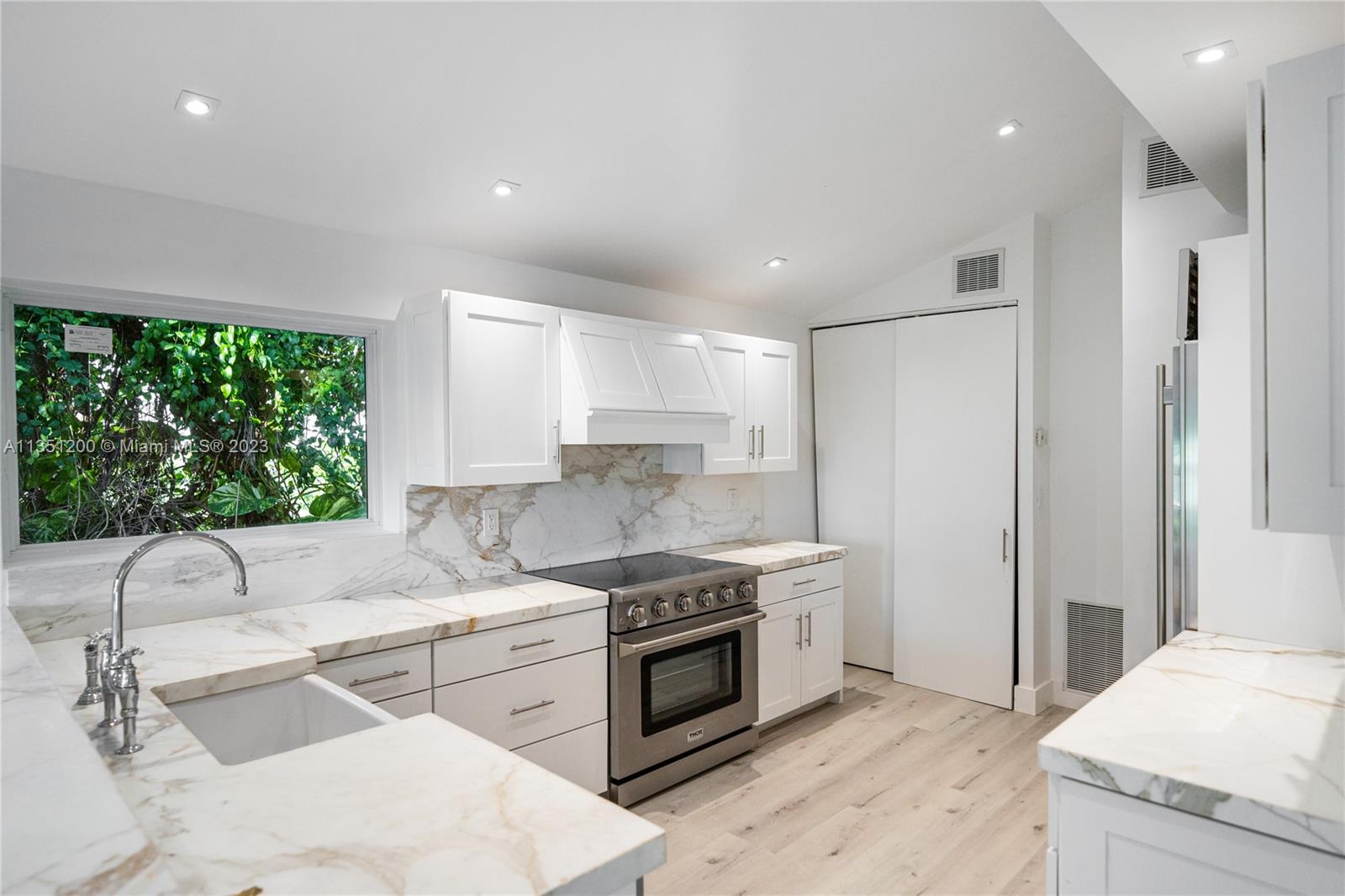 5512 La Gorce Drive Miami Beach, FL 33140 - Photo 15 of 35 a kitchen with a stove a sink and a refrigerator