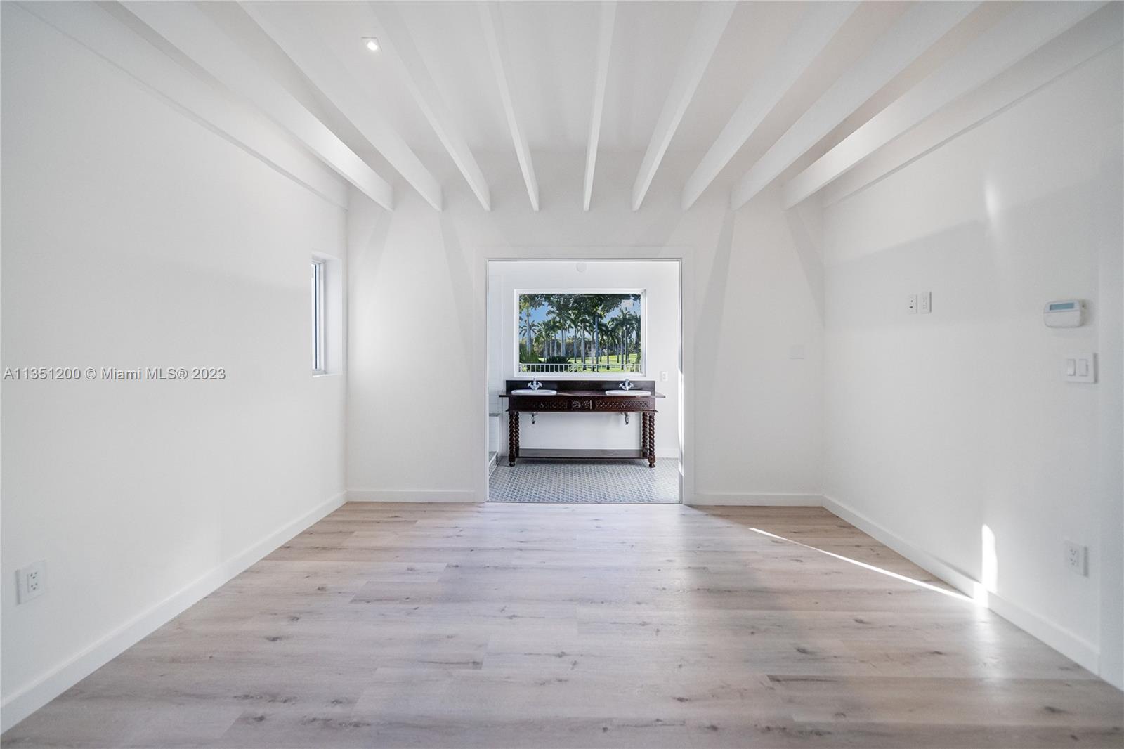 5512 La Gorce Drive Miami Beach, FL 33140 - Photo 31 of 35 a view of an empty room with wooden floor and a window
