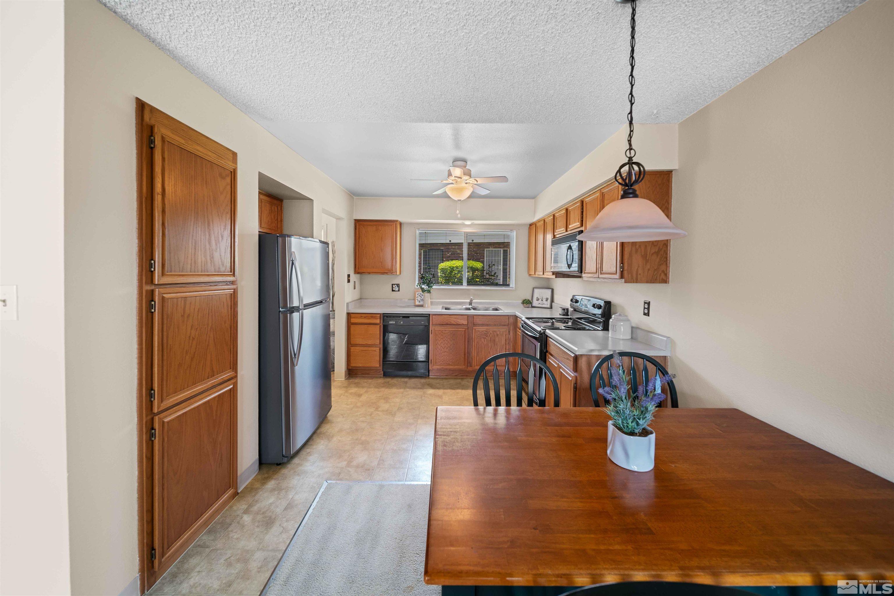 426 Smithridge Drive Reno, NV 89502 - Photo 4 of 20 a kitchen with stainless steel appliances granite countertop a refrigerator a sink a stove and a dining table with wooden floor