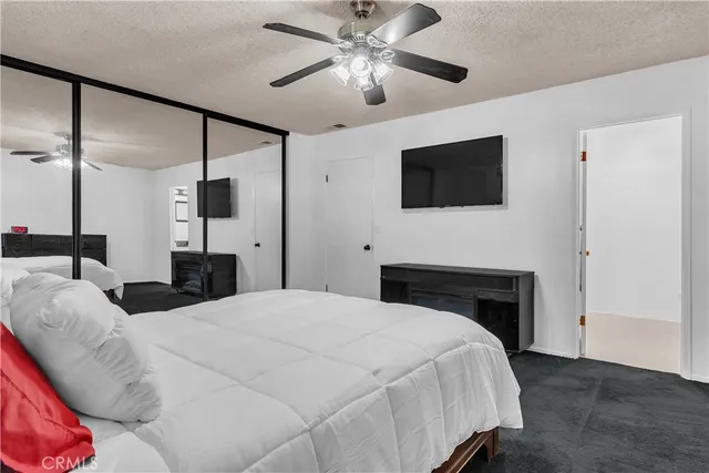 a large bedroom with a bed and a flat screen tv