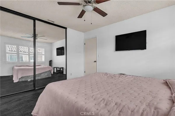 a bedroom with a bed window and a flat screen tv
